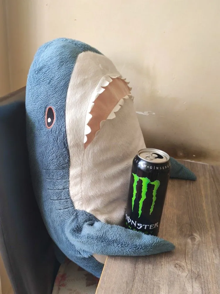 Plush toy shark holding an original Monster Energy can